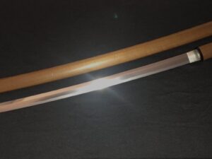 Two wooden sticks crossed on a dark surface.