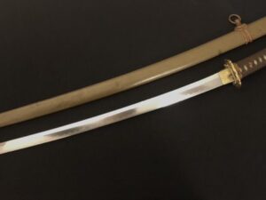 A polished katana sword with a wooden scabbard on a black surface.