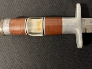 Close-up of a metal tool with a wooden handle and measuring scale.