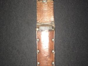 Close-up of a brown leather watch strap with metal rivets.