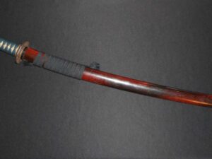 Close-up of a red and gray handled tool against a dark background.