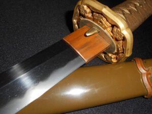 Close-up of a detailed Japanese-style dagger with ornate guard and polished blade.