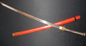 A traditional Japanese katana with a red scabbard.