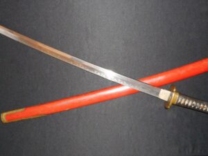 A traditional Japanese katana with a red scabbard.