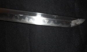Close-up of a sword blade with visible hamon pattern.