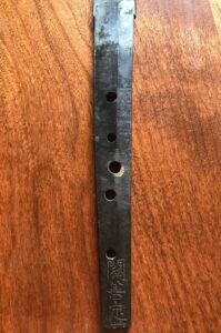 Close-up of a worn black guitar strap with multiple adjustment holes.
