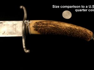 Close-up of a knife handle made from antler with a small moon in the background.