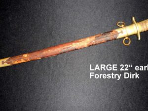 Large rusty forestry drill with a wooden handle on a dark surface.