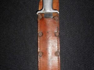 Close-up of a knife handle on a leather sheath with metal rivets.