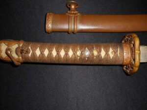 Close-up of a katana handle and wooden scabbard with diamond-patterned wrapping.