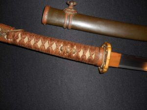 Close-up of a katana handle with a traditional wrapped grip and wooden sheath.