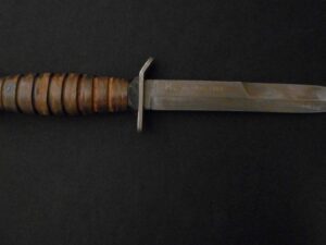 Close-up of a knife with a wooden handle on a black background.