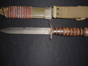 Two vintage knives with leather-wrapped handles on a black surface.