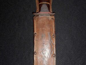 Rusty fixed-blade knife in a weathered leather sheath.