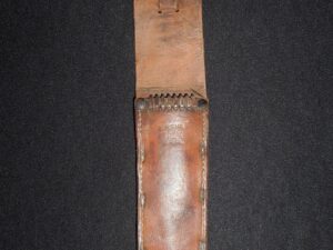 Vintage leather sheath with buttoned flap on black background.