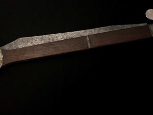 Close-up of a rusty metal rod against a dark background.