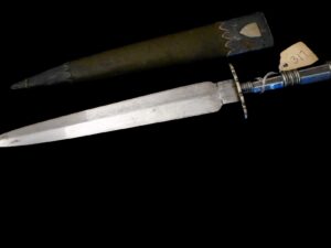 A dagger with a decorated sheath on a black background.