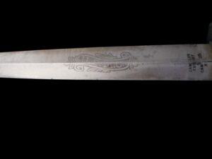 Close-up of a sword blade with etched decorative patterns.