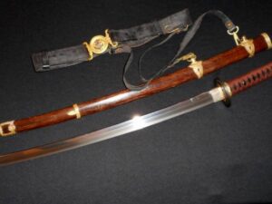 A traditional Japanese samurai sword with a wooden scabbard and a belt.