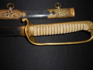 Close-up of a vintage sword with ornate handle and scabbard.