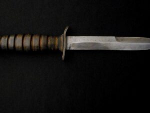 Close-up of a vintage combat knife with a worn handle and blade.