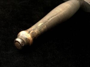 Close-up of a wooden baseball bat handle with a black background.